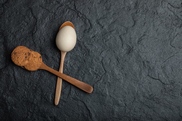 Biscoito e ovo cru na superfície escura