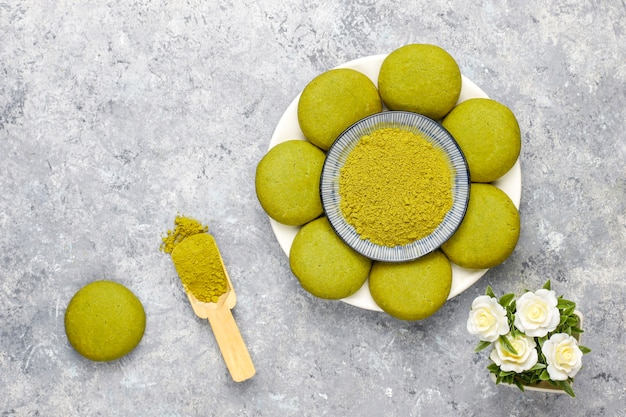 Biscoitos caseiros de chá verde matcha com pó de matcha na mesa de concreto cinza