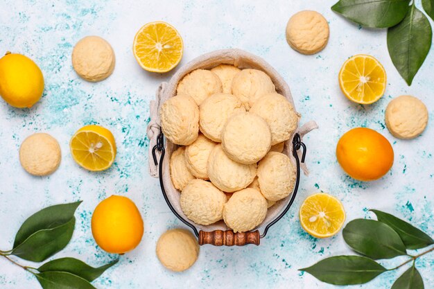Biscoitos caseiros de limão com limões na superfície da luz
