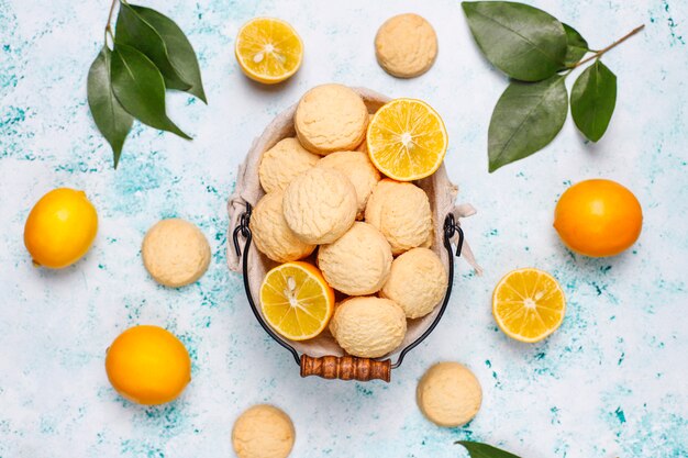 Biscoitos caseiros de limão com limões na superfície da luz