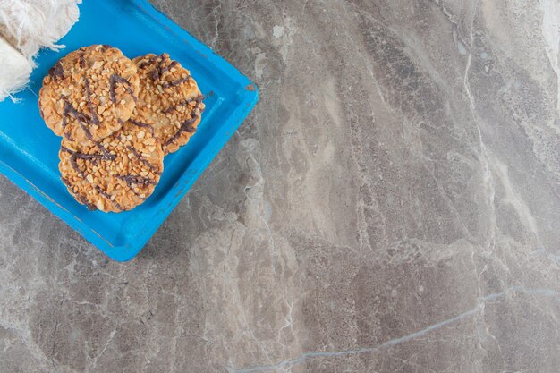 Biscoitos caseiros e algodão doce turco em uma placa de madeira em azul.