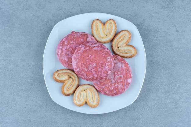 Biscoitos caseiros frescos. Biscoitos-de-rosa na chapa branca.