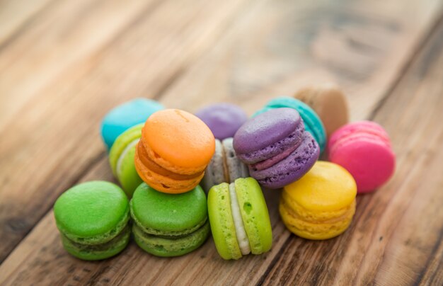 biscoitos coloridos com recheio em cima de uma mesa de madeira