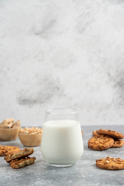 Biscoitos com amendoim orgânico e mel com copo de leite na mesa de mármore.