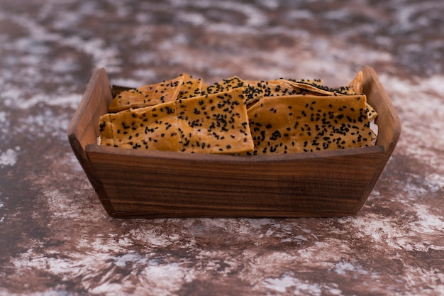 Foto grátis biscoitos com cominho preto em bandeja de madeira, vista de ângulo.