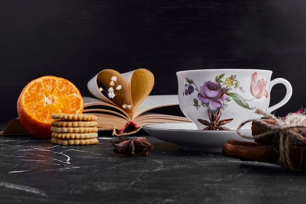 Biscoitos com laranja e uma xícara de chá.