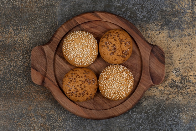 Foto grátis biscoitos com sementes de gergelim e pedaços de chocolate na placa de madeira.