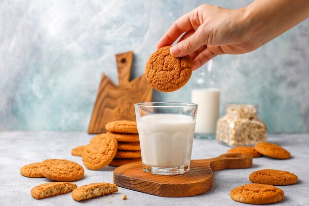 Biscoitos de aveia caseiros com um copo de leite.