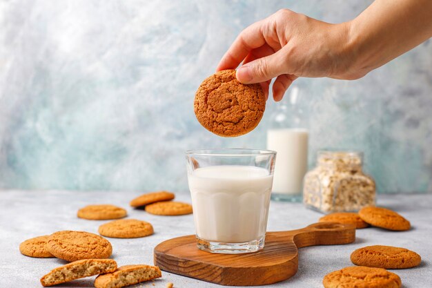 Biscoitos de aveia caseiros com um copo de leite.