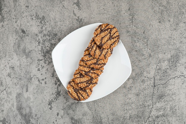 Foto grátis biscoitos de aveia cozidos frescos polvilhados com sementes na chapa branca.