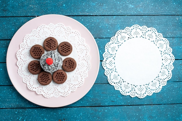 Biscoitos de chocolate deliciosos com bolo de chocolate em azul de mesa rústico biscoito de mesa biscoito doce bolo de açúcar