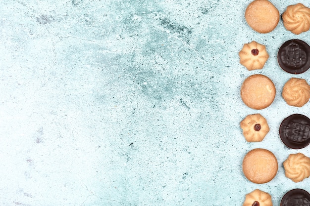 Biscoitos de chocolate e aveia em uma mesa azul.