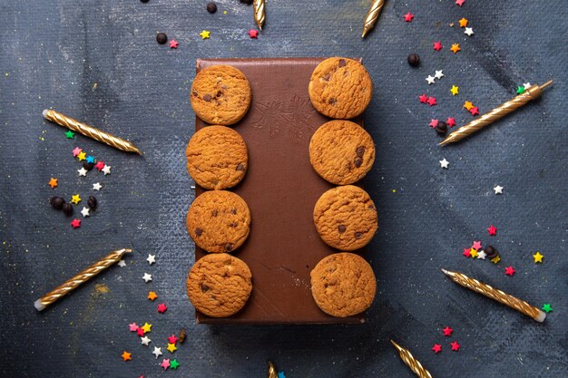 Biscoitos de chocolate saborosos na caixa marrom com velas na mesa cinza-escuro biscoito biscoito chá doce