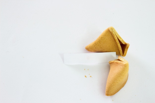 Biscoitos de fortuna quebrada com deslizamento em branco isolado no fundo branco