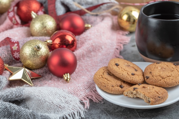 Biscoitos de gengibre em um pires branco com figuras de natal ao redor