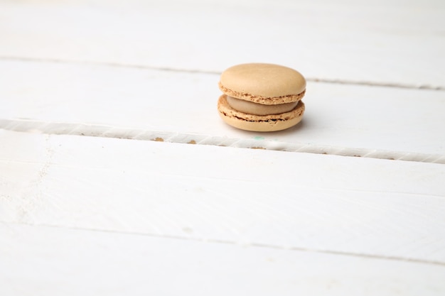 Biscoitos de macaroon marrons doces e deliciosos na superfície de madeira