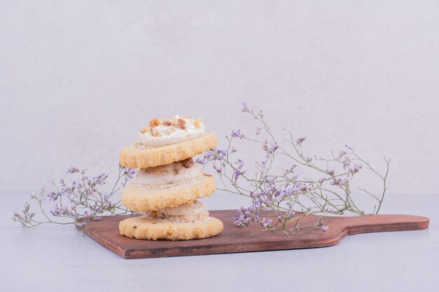 Biscoitos de manteiga com chantilly na travessa de madeira.