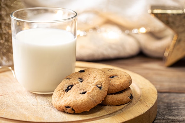 Biscoitos de natal e copo de leite para o papai noel no fundo desfocado de férias