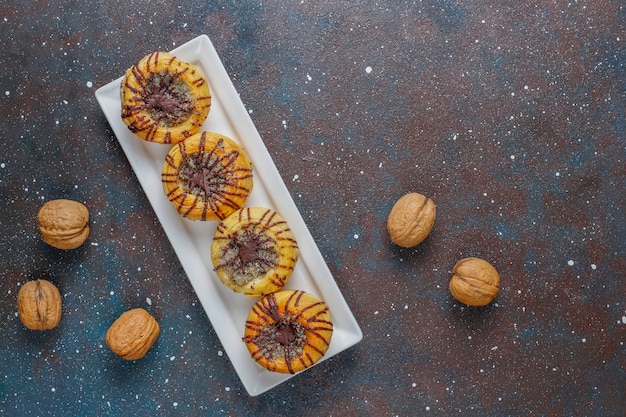 Biscoitos de nozes e chocolate com nozes ao redor, vista superior