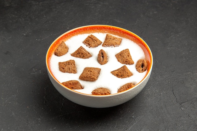 Biscoitos de travesseiro com leite no café da manhã no escuro