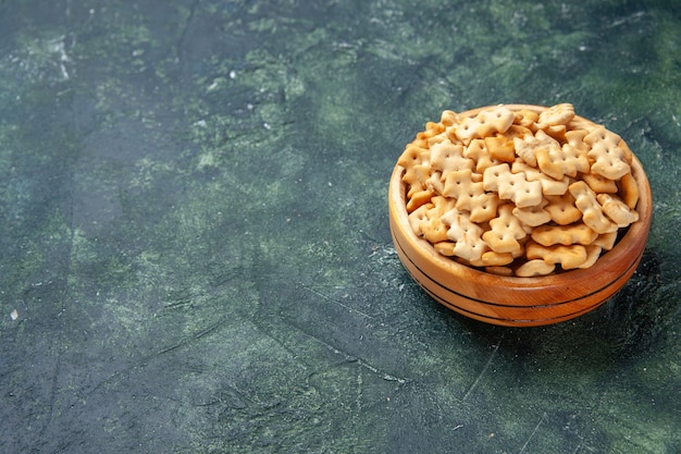 Foto grátis biscoitos de vista frontal dentro do prato em fundo escuro salgadinho torrado crocante tostas de alimentos cor cips