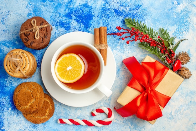 Biscoitos de xícara de chá com vista superior amarrados com uma caixa de presente de corda na mesa azul