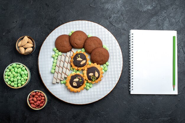 Biscoitos deliciosos com diferentes doces em cima de uma mesa cinza escuro biscoito doce bolo torta chá biscoito