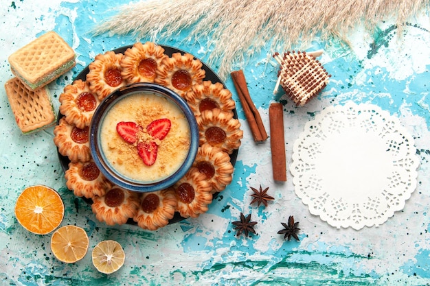 Biscoitos deliciosos com waffles e sobremesa de morango em cima da mesa azul