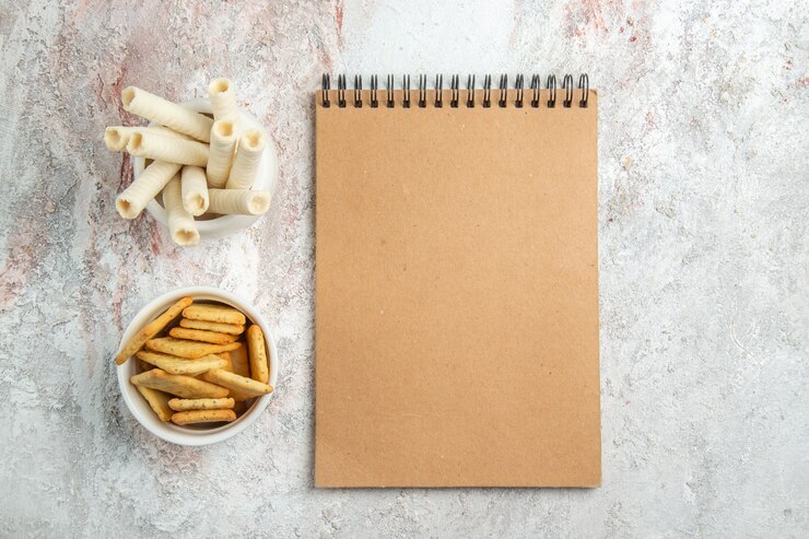 Foto grátis biscoitos doces com bolachas e um bloco de notas na mesa branca de biscoitos doces