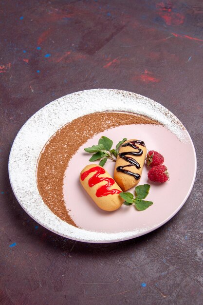 Biscoitos doces de vista frontal dentro de um prato desenhado no espaço escuro