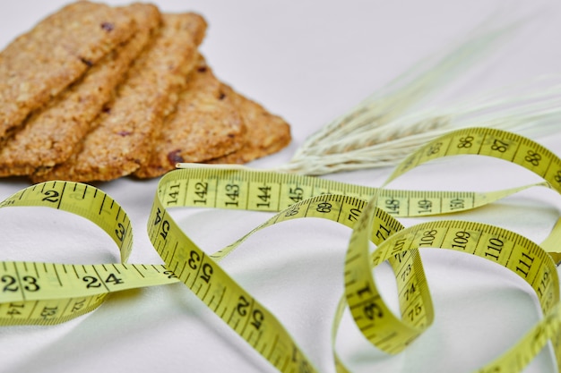 Biscoitos e fita métrica em um fundo branco. Foto de alta qualidade