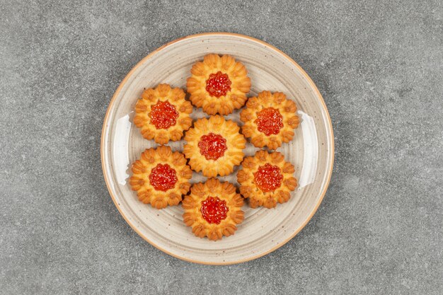 Biscoitos em forma de flor com geleia em prato de cerâmica