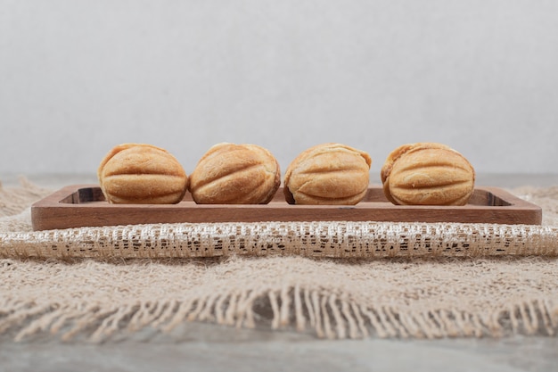 Biscoitos em forma de noz na placa de madeira.