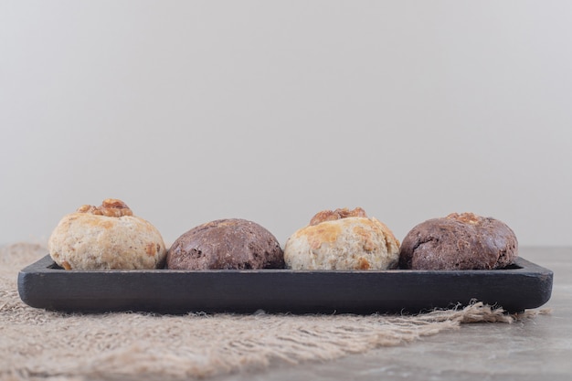 Biscoitos em uma pequena bandeja sobre um pedaço de pano sobre mármore