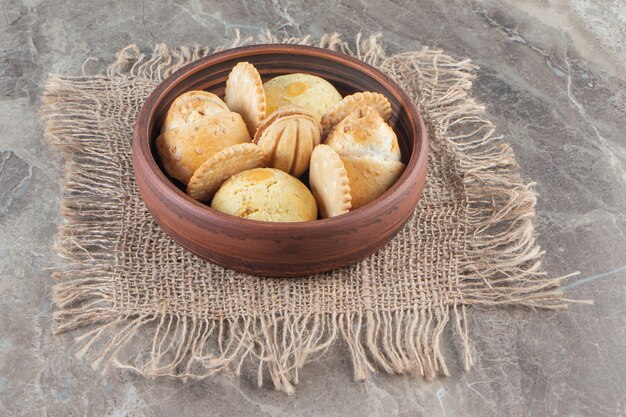 Biscoitos em uma tigela na textura fecham em mármore.