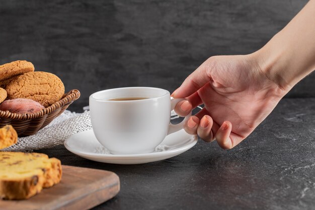 Biscoitos em uma travessa de madeira servidos com uma xícara de chá.