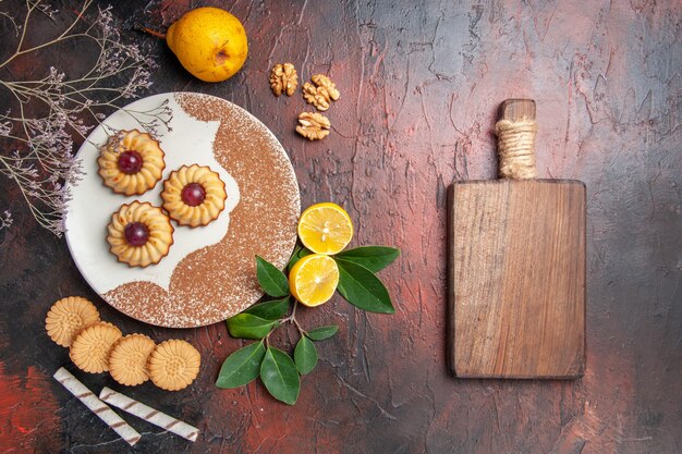 Biscoitos saborosos com frutas na mesa escura Bolo de açúcar biscoito doce