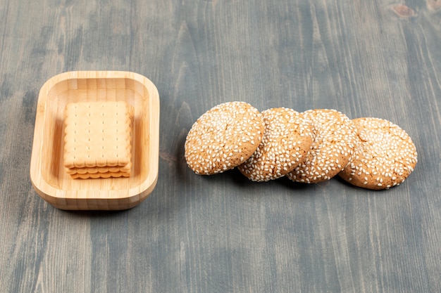 Biscoitos saborosos com pãezinhos em uma mesa de madeira