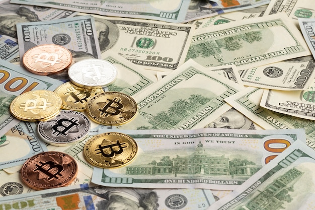 Bitcoin colorido diferente em cima de notas de dólar