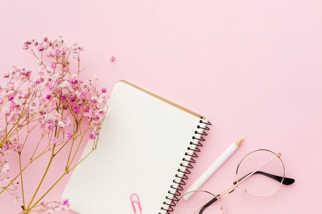 Foto grátis bloco de notas branco vazio e flores plana leigos