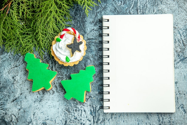 Bloco de notas de biscoitos de árvore de natal na mesa cinza, vista superior, galho de pinho, galho de pinho