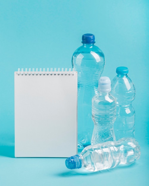 Foto grátis bloco de notas e garrafas de água com gás