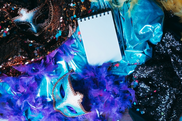 Foto grátis bloco de notas em espiral sobre adereços de carnaval elegante