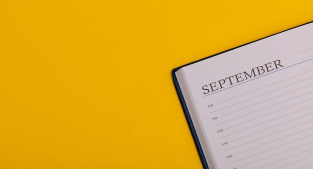 Bloco de notas ou diário em um fundo amarelo calendário para setembro tempo para o outono espaço para texto