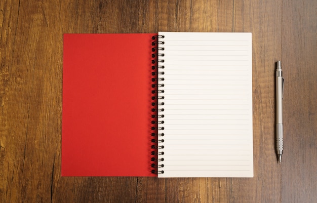 Bloco de notas vermelho com uma caneta perto