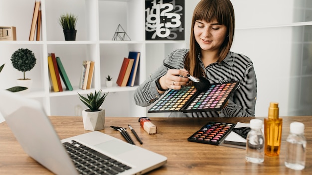 Blogueira de maquiagem feminina com streaming em casa com laptop