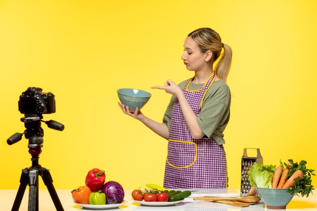 Blogueiro de comida adorável chef saudável gravando vídeo para mídias sociais apontando para a tigela