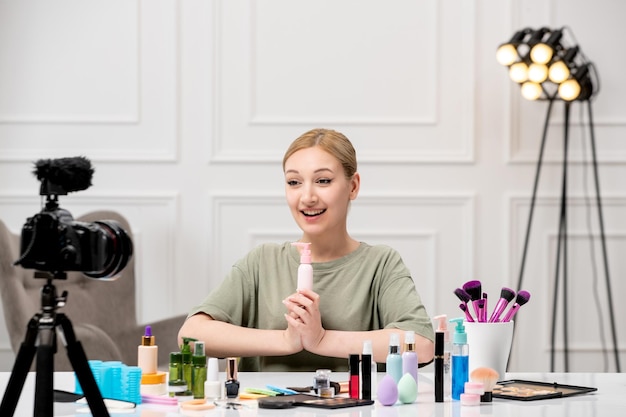 Blogueiro de maquiagem criando tutorial de maquiagem na câmera jovem bonita e bonita animada por creme