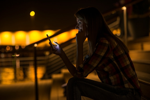 Foto grátis boas notícias. jovem, mulher feliz, enviando mensagens de texto em seu telefone