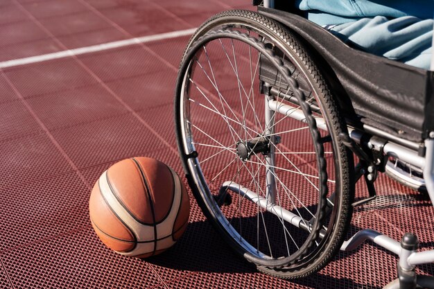 Bola de basquete de ângulo alto e cadeira de rodas